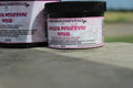 Angel Muffin Mud 8 oz jar placed outdoors, emphasizing natural recovery for sore legs and joints of horses.