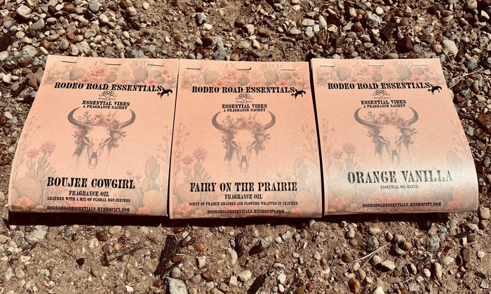 Rodeo Road Essentials Car or Trailer Sachet featuring three distinct scents: Boujee Cowgirl, Fairy on the Prairie, and Orange Vanilla, displayed against a rustic gravel background.